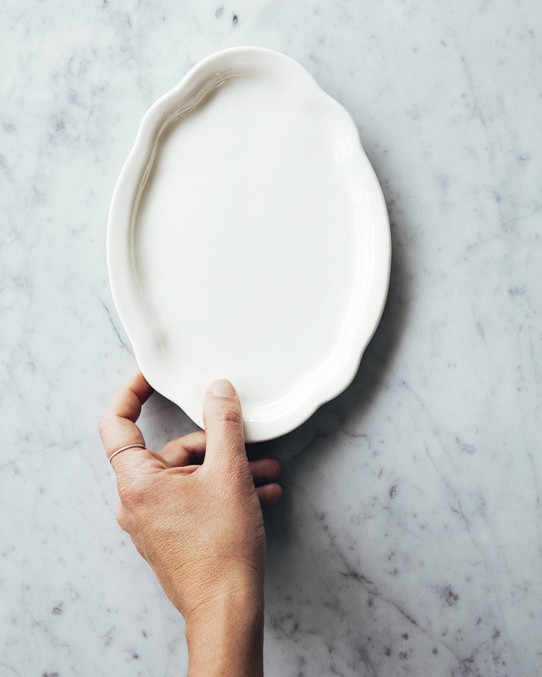 These lovely oval dessert plates are perfect for serving a decadent after dinner treat, and simple enough for your morning toast or pastry. Glazed porcelain, hand-painted with a 14 karat gold line.Ces jolies assiettes à dessert ovales sont parfaites pour servir une gâterie décadente après le souper et assez simples pour votre rôtie ou pâtisserie matinale. Faites de porcelaine émaillée, peintes à la main et ornées d’une ligne dorée de 14 carats. 